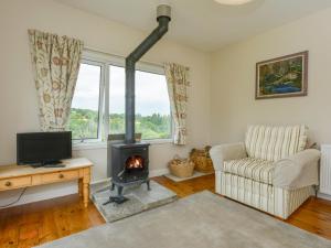 a living room with a fireplace and a couch at Kestorway in Gidleigh