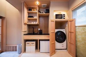 a kitchen with a washer and dryer in a tiny house at Rinn Tsukinowa West in Kyoto