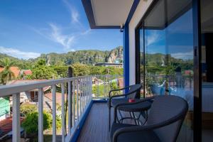 a balcony with two chairs and a view of the mountains at @Aonang Guesthouse in Ao Nang Beach