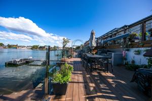 a deck with a table and an umbrella next to the water at Gold Coast Mermaid Waters Duplex House in Gold Coast