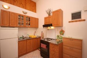 a kitchen with wooden cabinets and a stove top oven at Apartments with WiFi Pula - 6987 in Pula