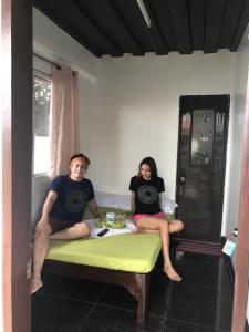a man and a woman sitting on a table at Jancas Vacation Home Camiguin Couple Room 1 in Catarman