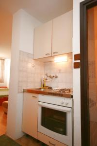 a kitchen with white cabinets and a stove top oven at Apartments with a parking space Mareda, Novigrad - 7100 in Novigrad Istria