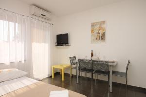 フンタナにあるApartments with a parking space Funtana, Porec - 7076のベッドルーム(テーブル、壁掛けテレビ付)