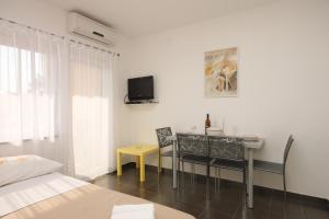 a bedroom with a table and a tv on the wall at Apartments with a parking space Funtana, Porec - 7076 in Funtana