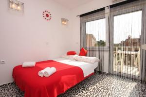 フンタナにあるApartments with a parking space Funtana, Porec - 7076のベッドルーム1室(赤と白のベッド1台、大きな窓付)