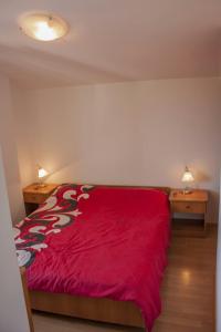 1 dormitorio con 1 cama roja y 2 mesitas de noche en Apartments with a swimming pool Motovun - Bataji, Central Istria - Sredisnja Istra - 7069, en Motovun