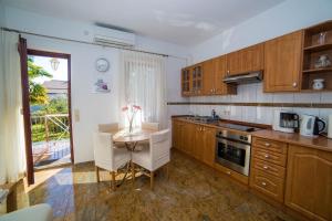 een keuken met houten kasten en een tafel met stoelen bij Apartments with parking space Porec - 6984 in Poreč