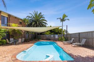 a swimming pool with a hammock on a patio at The Anchorage Bermagui in Bermagui