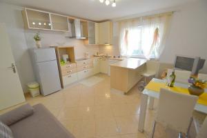 eine Küche mit einem weißen Kühlschrank und einem Tisch in der Unterkunft Apartments with a parking space Novigrad - 7054 in Novigrad Istria + 26 Fotos