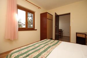 1 dormitorio con cama y ventana en Apartment Porec 7042b, en Poreč