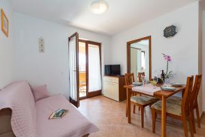 salon ze stołem i kanapą w obiekcie Apartments with a swimming pool Novigrad - 7078 w mieście Novigrad