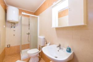łazienka z toaletą, umywalką i prysznicem w obiekcie Apartments with a swimming pool Novigrad - 7078 w mieście Novigrad