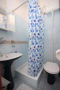 a bathroom with a toilet and a shower curtain at Apartments with a parking space Porec - 7024 in Poreč