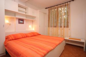 a bedroom with an orange bed and a window at Apartments with a parking space Porec - 7024 in Poreč