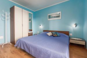 een blauwe slaapkamer met een bed en een blauwe muur bij Apartments with a parking space Porec - 7012 in Poreč
