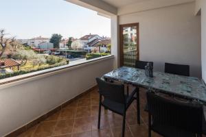 een balkon met een tafel en stoelen en een raam bij Apartments with a parking space Porec - 7012 in Poreč