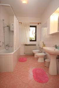 a bathroom with a tub and a sink and a toilet at Apartments with a parking space Novigrad - 7020 in Novigrad Istria