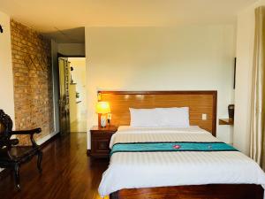 a bedroom with a large bed with a wooden headboard at Maison Vu Tri Vien in Hue