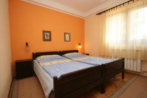 een bed in een slaapkamer met een oranje muur bij Apartments by the sea Umag - 7029 in Umag