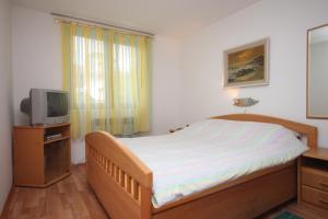 a bedroom with a bed and a television at Apartments with a parking space Zambratija, Umag - 7059 in Zambratija