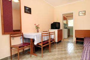 a living room with a table and chairs and a television at Holiday house with a parking space Tar, Porec - 7025 in Tar