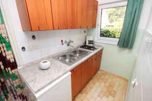 a small kitchen with a sink and a window at Holiday house with a parking space Tar, Porec - 7025 in Tar