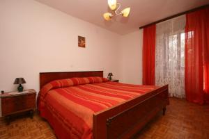 a bedroom with a bed with red sheets and a window at Apartments by the sea Zambratija, Umag - 7030 in Zambratija