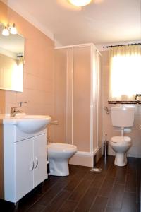 a bathroom with a sink and a toilet and a shower at Apartments by the sea Zambratija, Umag - 7030 in Zambratija