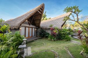 a house with a thatched roof and a garden at Villa Amantes Bingin in Uluwatu