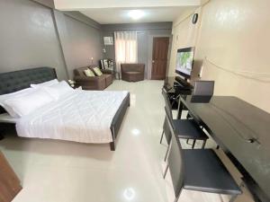 Dormitorio con cama, escritorio y TV en Adam's Hotel Apartment en Pandi