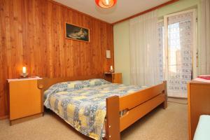 een slaapkamer met een bed met een houten muur bij Apartments with a parking space Umag - 6994 in Umag