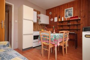 een keuken met een tafel en stoelen in een kamer bij Apartments with a parking space Umag - 6994 in Umag