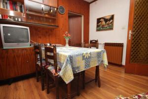 a dining room with a table and a tv at Apartments with parking space Umag - 6994 in Umag