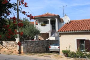 a house with a car parked in front of it at Apartments with a parking space Tar, Porec - 7026 in Tar
