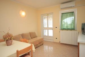 a living room with a couch and a table at Apartments with a parking space Tar, Porec - 7026 in Tar