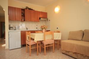a kitchen and dining room with a table and chairs at Apartments with a parking space Tar, Porec - 7026 in Tar