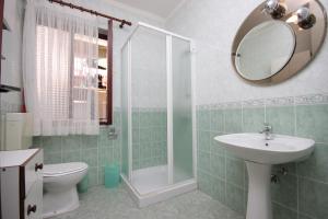 W łazience znajduje się toaleta, umywalka i lustro. w obiekcie Apartments with a parking space Umag - 6959 w mieście Umag