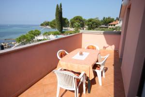 a table and chairs on a balcony with a view of the ocean at Apartments by the sea Zambratija, Umag - 6997 in Zambratija