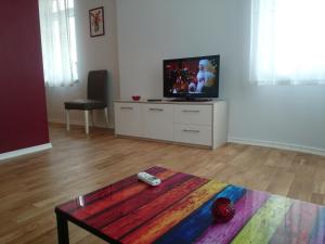 a living room with a tv and a table at The Central Post Apartments in Sofia