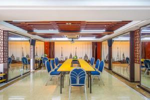 une salle de conférence avec une table jaune et des chaises bleues dans l'établissement Foshan Yumi Apartment Bodun Branch, à Foshan