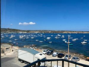 a group of boats in a marina with a truck at Sea front apartment at Mellieha Bay, Malta! in Mellieħa