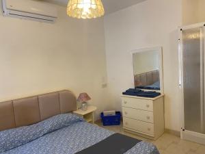 Schlafzimmer mit einem Bett, einer Kommode und einem Spiegel in der Unterkunft Sea front apartment at Mellieha Bay, Malta! in Mellieħa