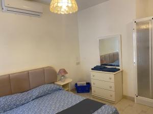 ein Schlafzimmer mit einem Bett, einer Kommode und einem Spiegel in der Unterkunft Sea front apartment at Mellieha Bay, Malta! in Mellieħa