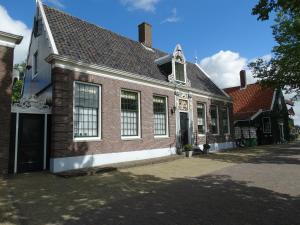 an old brick building with a window on a street at Heerlijck Slaapen op de Zaanse Schans in Zaandam