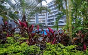 a garden with palm trees and plants in front of a building at Serviced apartment -Sheraton Al Matar (Ocean blue) in Cairo