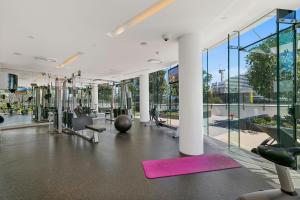 a gym with exercise equipment and large windows at Oracle Resort - Q Stay in Gold Coast