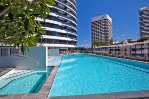 a large swimming pool next to a tall building at Oracle Resort - Q Stay in Gold Coast