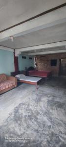 an empty room with couches and tables in a building at Lawang Inn in Bukit Lawang