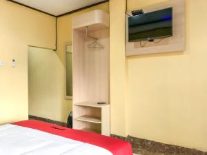 Tobadi的住宿－RedDoorz @ Gerson Hotel Abepura，一间设有床铺和墙上电视的房间